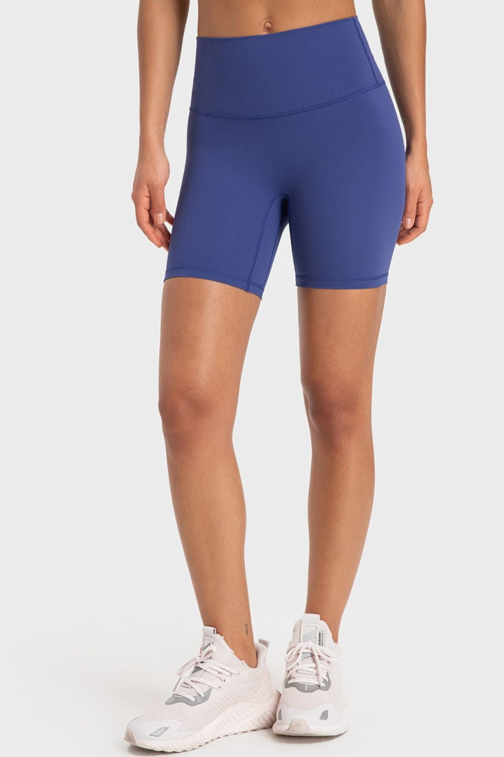 Model wearing solid blue wide-waistband biker shorts with a fitted mid-thigh silhouette, flat seams, and a sporty stretch design.