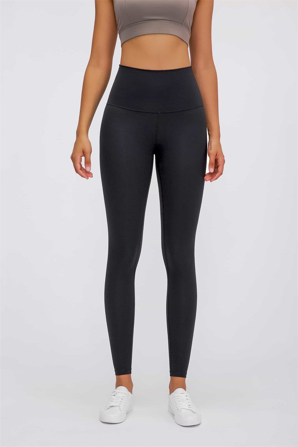 A model stands in black ultra soft high waist leggings with a wide elastic waistband, fitted full-length silhouette, and smooth stretch construction.