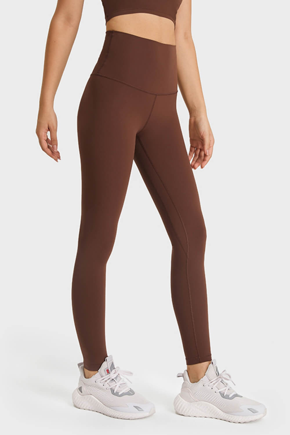 Model wears brown ultra-soft high waist leggings with a sleek, solid, full-length silhouette, stretchy fit, elastic waistband, and subtle leg seams.