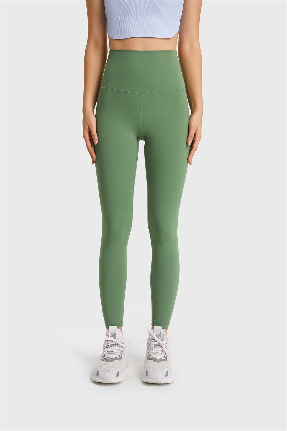 Model stands facing forward in olive green ultra-soft high-waist leggings with a smooth solid finish, elastic waistband, snug long silhouette, and visible seams.