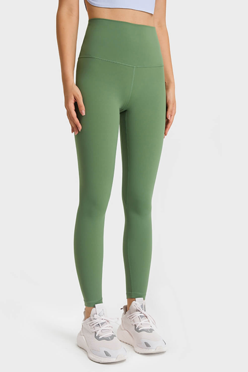 Model stands facing forward in solid sage green ultra soft high waist leggings with a wide elastic waistband, seamed construction, and fitted full-length silhouette.