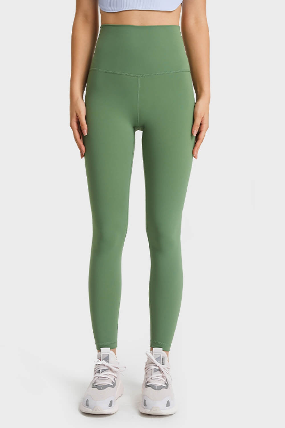 Model stands facing forward in solid olive-green ultra-soft high-waist leggings with a wide elastic waistband, smooth stretch fit, and tapered full-length silhouette.
