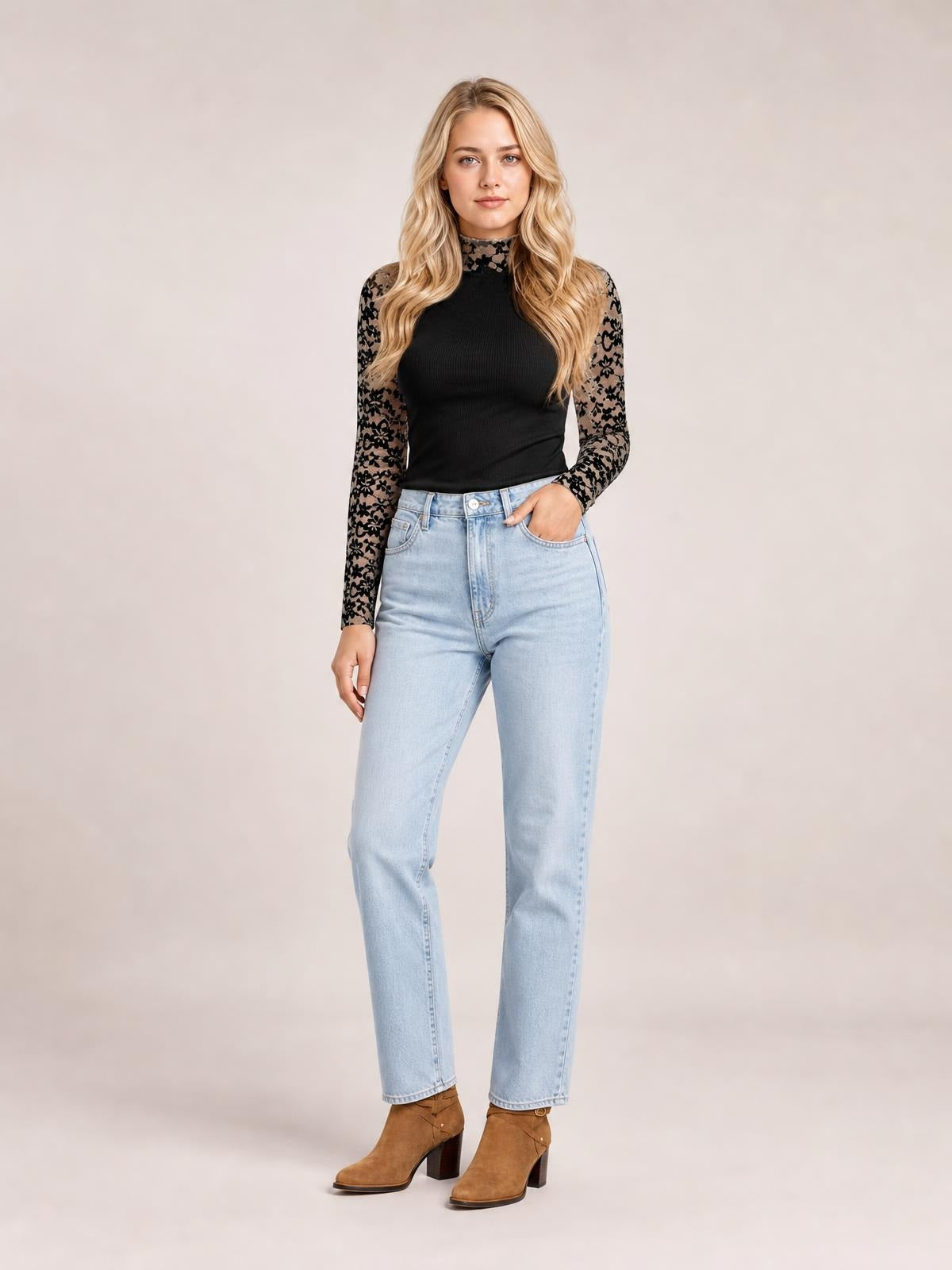 Model standing in a black mock neck long sleeve T-shirt with semi-sheer floral lace patchwork sleeves and a fitted silhouette.
