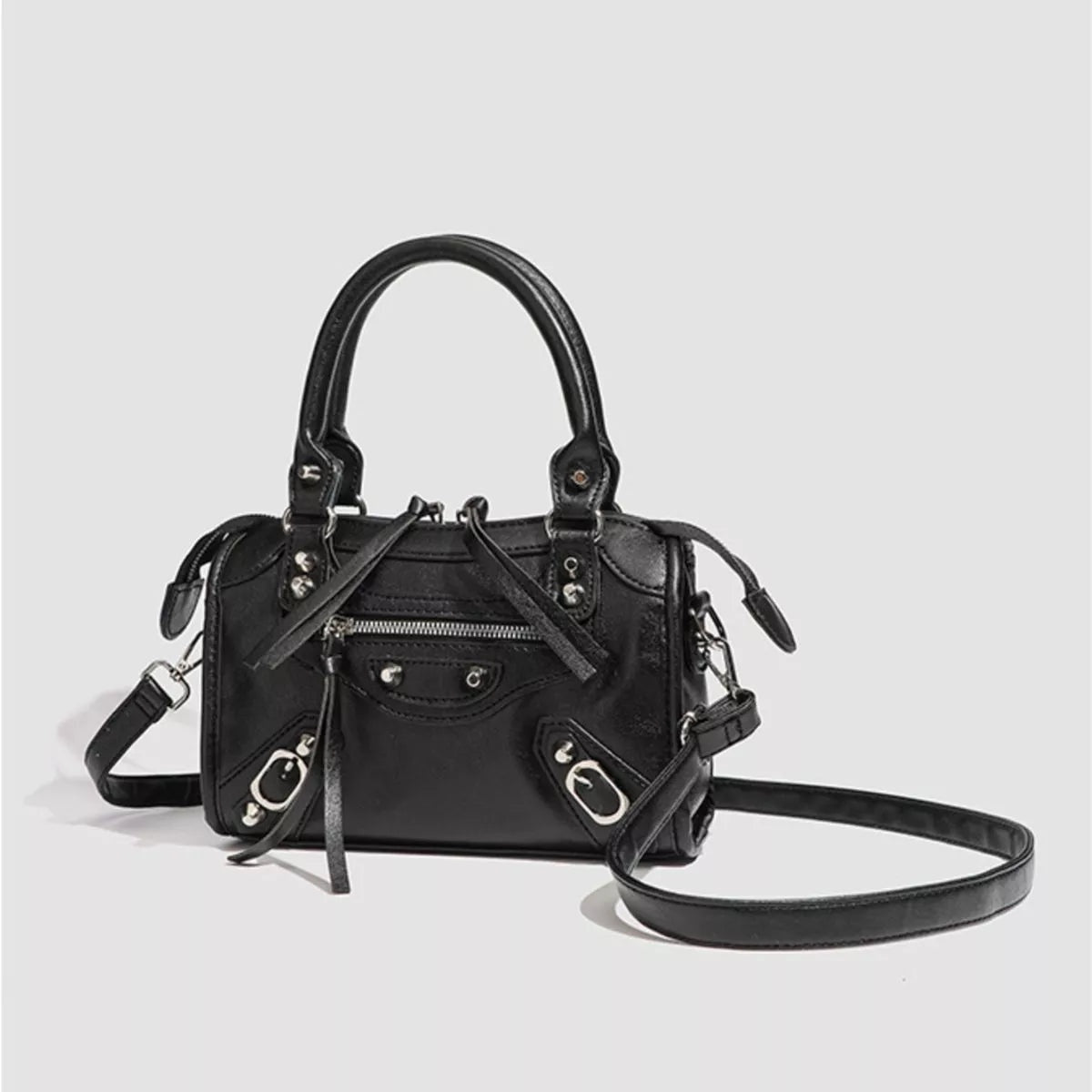 Small black PU leather motorcycle-style studded crossbody bag with top handles, multiple zip pockets, silver hardware, and a long detachable strap.