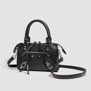 Small black PU leather motorcycle-style studded crossbody bag with top handles, multiple zip pockets, silver hardware, and a long detachable strap.