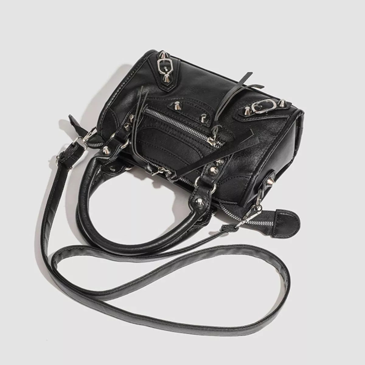 Small black PU leather crossbody bag with motorcycle styling, studded accents, dual top handles, multiple zippered compartments, and a long adjustable strap.