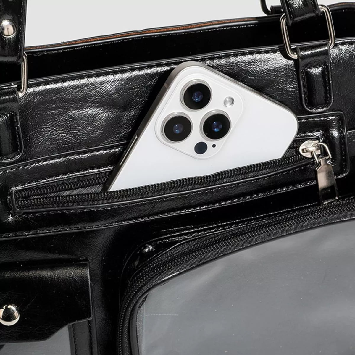 Black medium PU leather shoulder bag with multiple zippered pockets, silver hardware, and a clear window compartment displaying a smartphone.