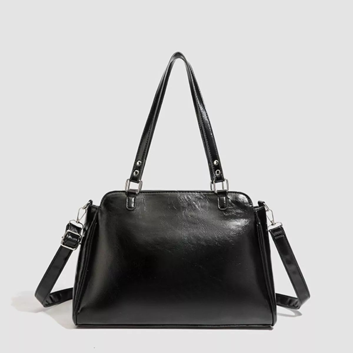 Black PU leather shoulder bag with a structured rectangular silhouette, dual top handles, detachable long strap, and silver-tone hardware.