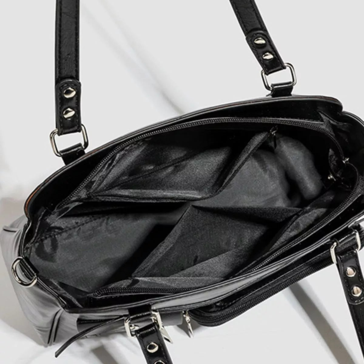 Black PU leather medium shoulder bag shown open, revealing multiple interior pockets, a spacious lined compartment, zip closure, and silver-tone hardware.
