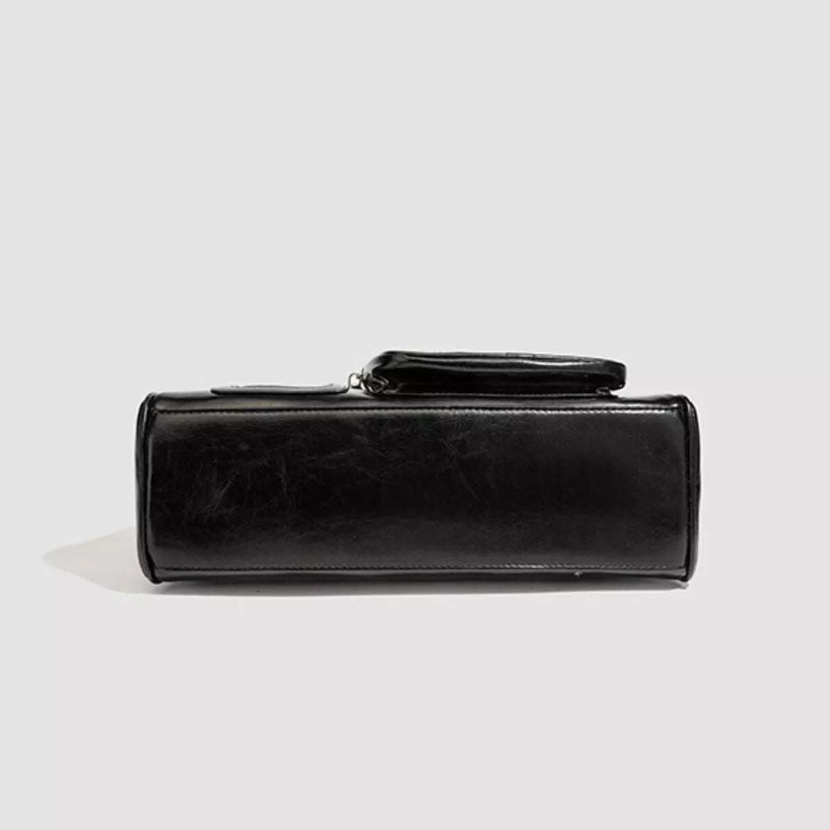 Black medium PU leather shoulder bag shown from below, featuring a structured rectangular silhouette, smooth panel, stitched edges, and a short top handle.