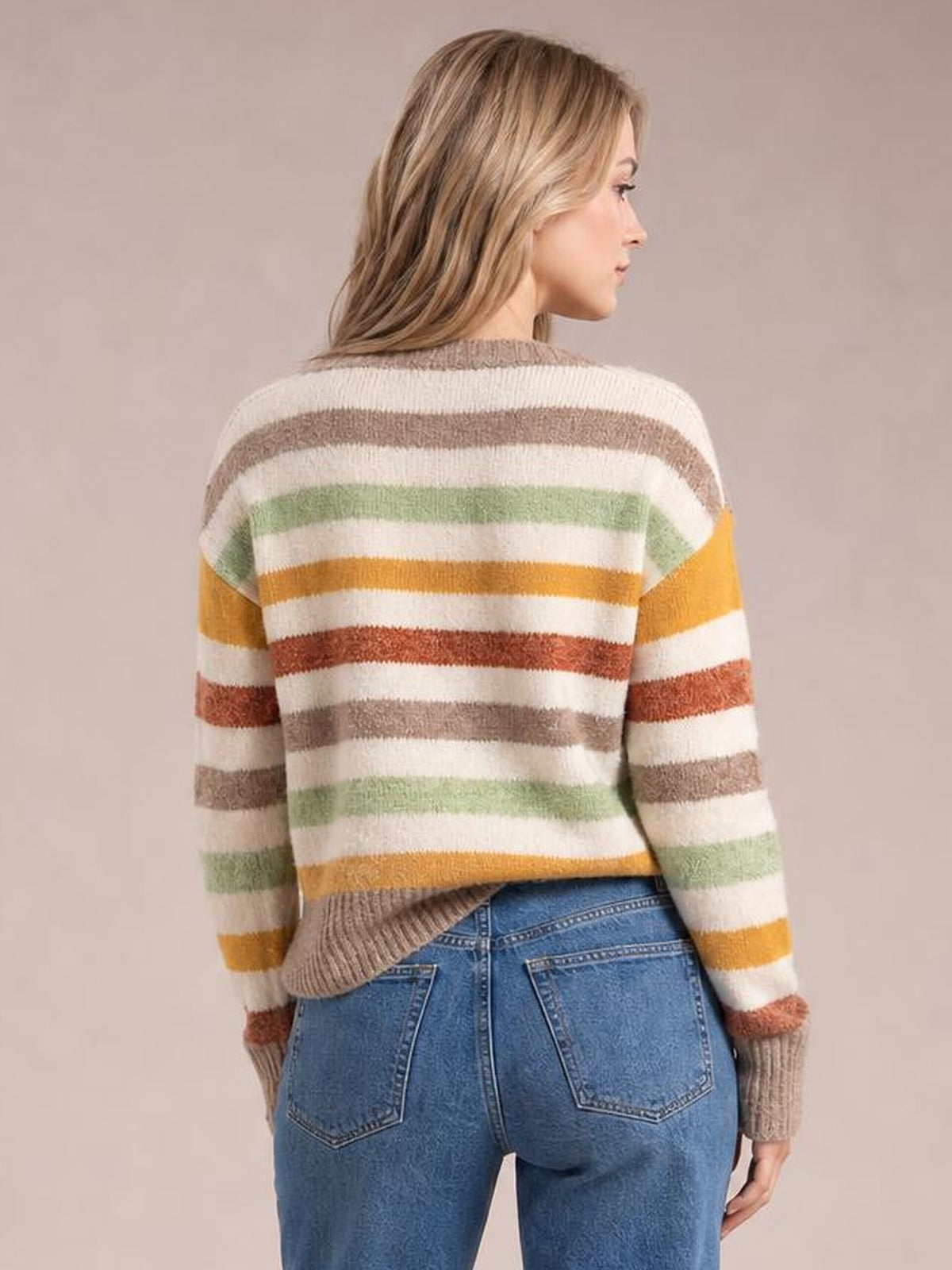 Model shown from behind in a relaxed pose wearing a multicolour stripe drop shoulder crew neck sweater with a loose silhouette and ribbed cuffs and hem.