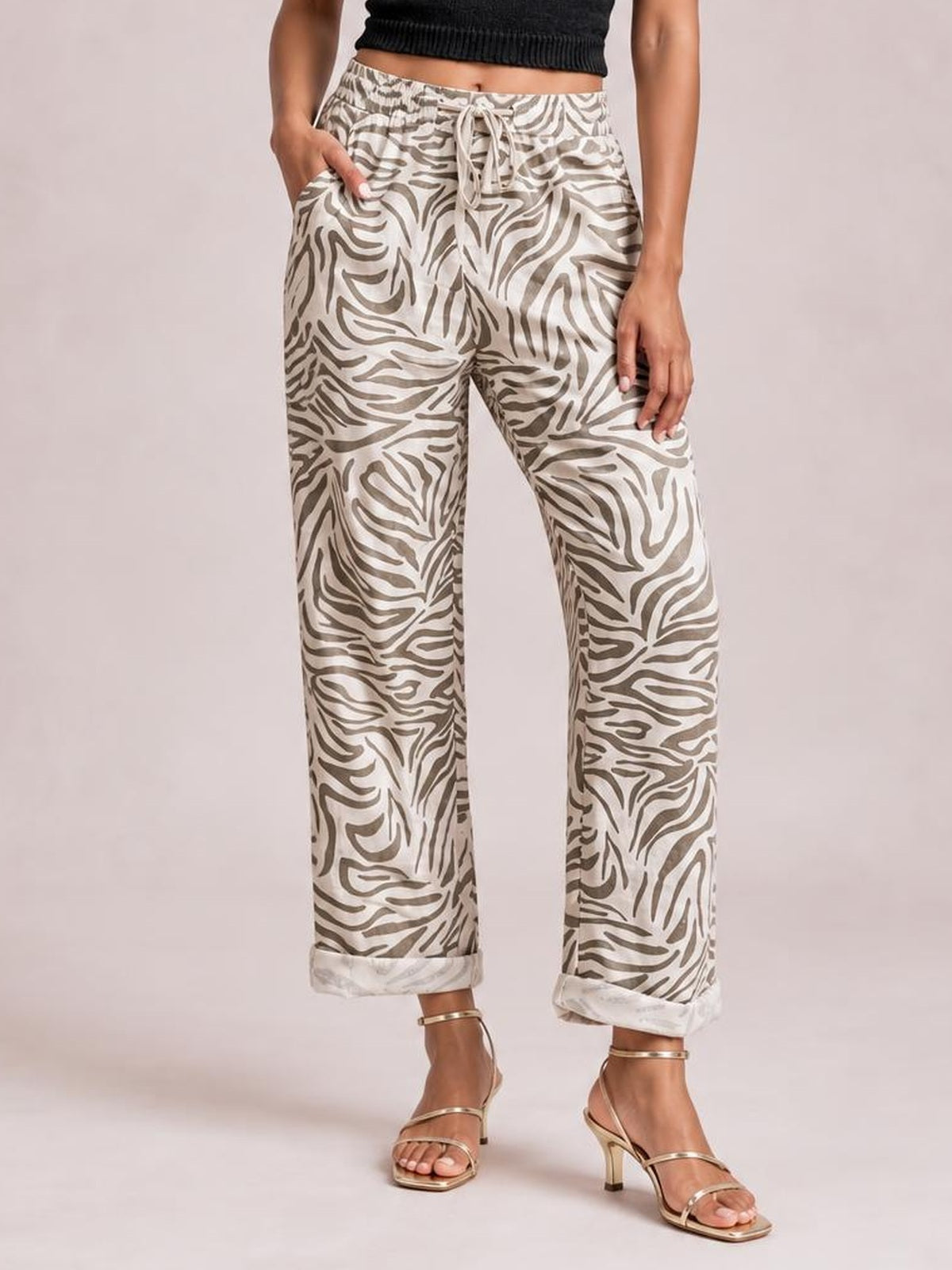 Model wears multicolour zebra-pattern western print pants with an elastic drawstring waist, side pockets, wide-leg silhouette, and rolled cuffs.