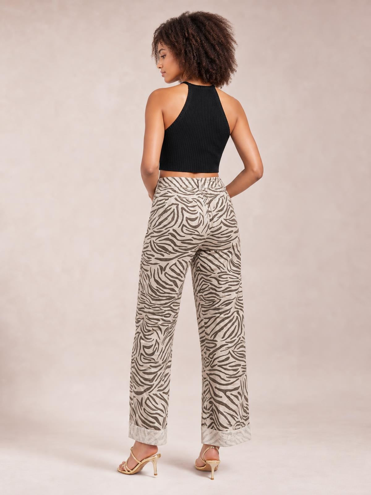 Model shown from behind in multicolour zebra-print pants with an elastic waist, wide-leg silhouette, side pockets, and folded cuffs.
