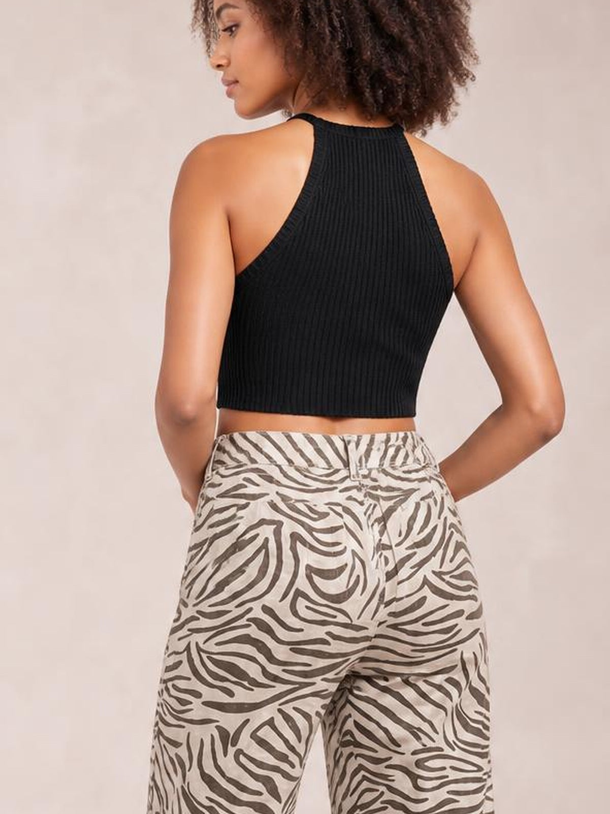 Model shown from behind wears multicolour western print zebra pattern pants with a high elastic waist, relaxed straight-leg silhouette, and hands at her hips.