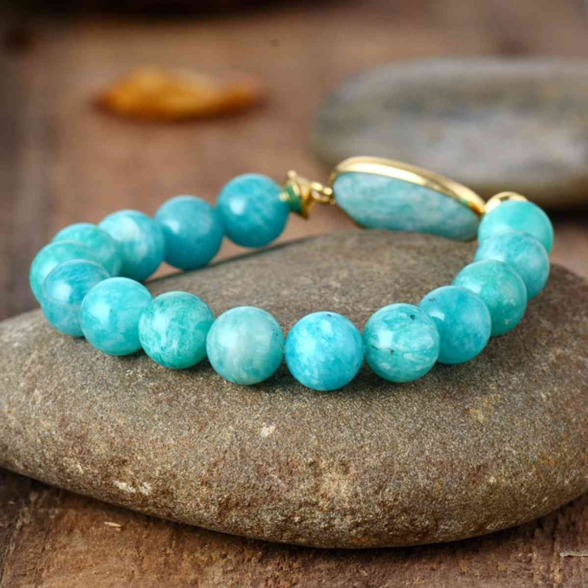 Turquoise natural stone beaded bracelet featuring round marbled beads, a larger oblong center stone, and gold-tone connector accents.