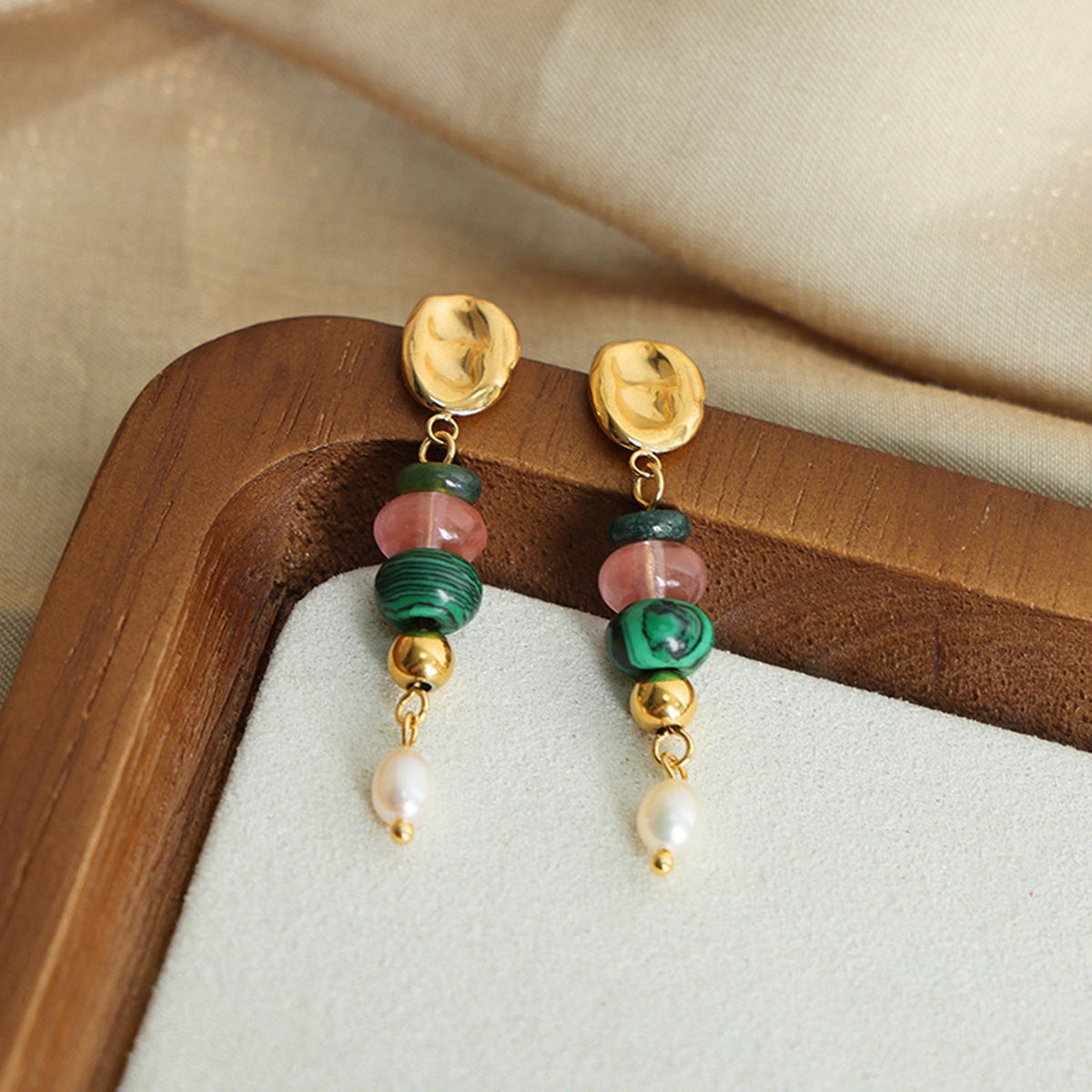 Natural stone freshwater pearl dangle earrings feature gold-tone oval studs, green and pink stone beads, and polished pearl drops in an elegant long silhouette.