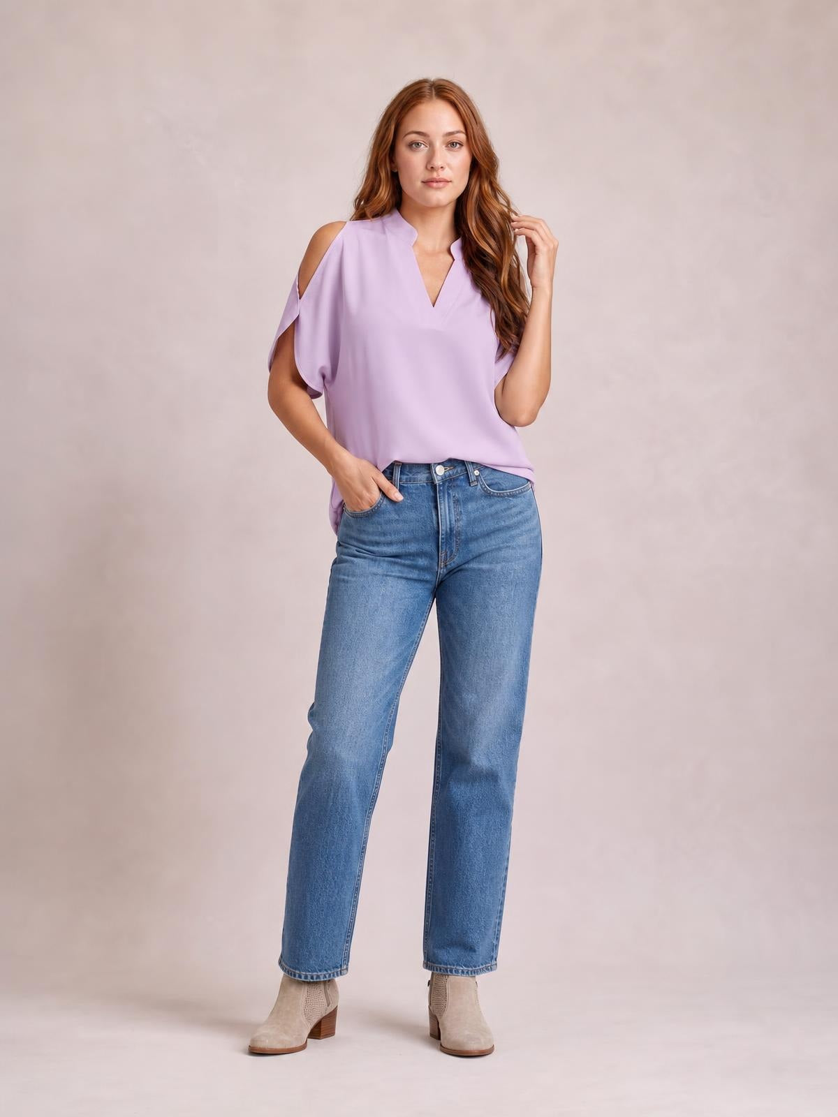 Model poses in a lilac Notched Cold Shoulder Blouse with a notched V-neck, shoulder cutouts, short sleeves, and a relaxed silhouette.