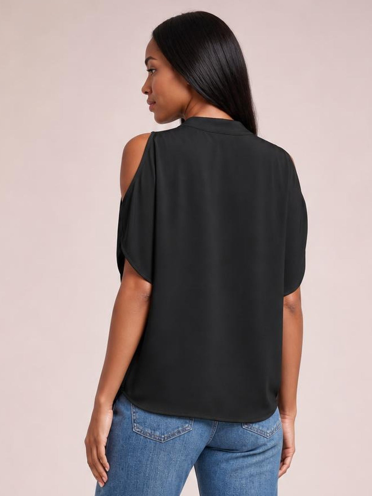 Model shown from the back wears a black opaque cold shoulder blouse with half sleeves, relaxed silhouette, rounded hem, and exposed shoulders.