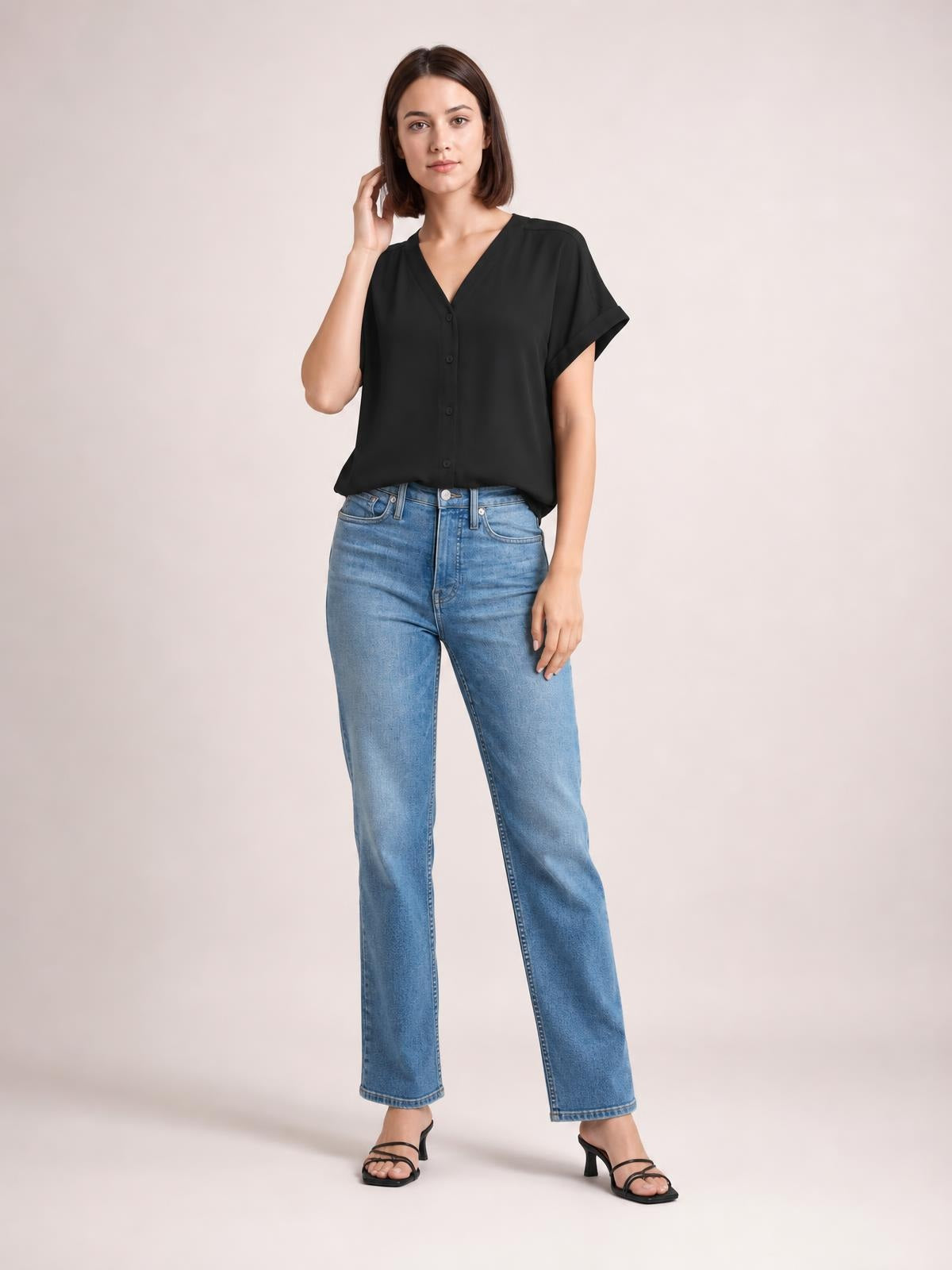 Model poses in a solid black notched-neck shirt with button front, short cuffed sleeves, and a relaxed regular-length silhouette.