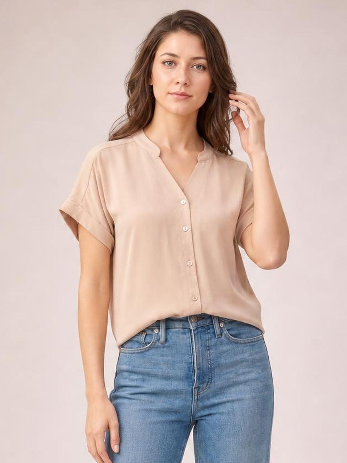 Model wears a solid beige notched neck shirt with cuffed short sleeves, button-front construction, and a relaxed regular-length silhouette.