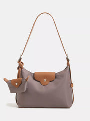 Medium taupe nylon hobo shoulder bag with brown trim, a long strap, front flap snap closure, and matching attached coin purse.