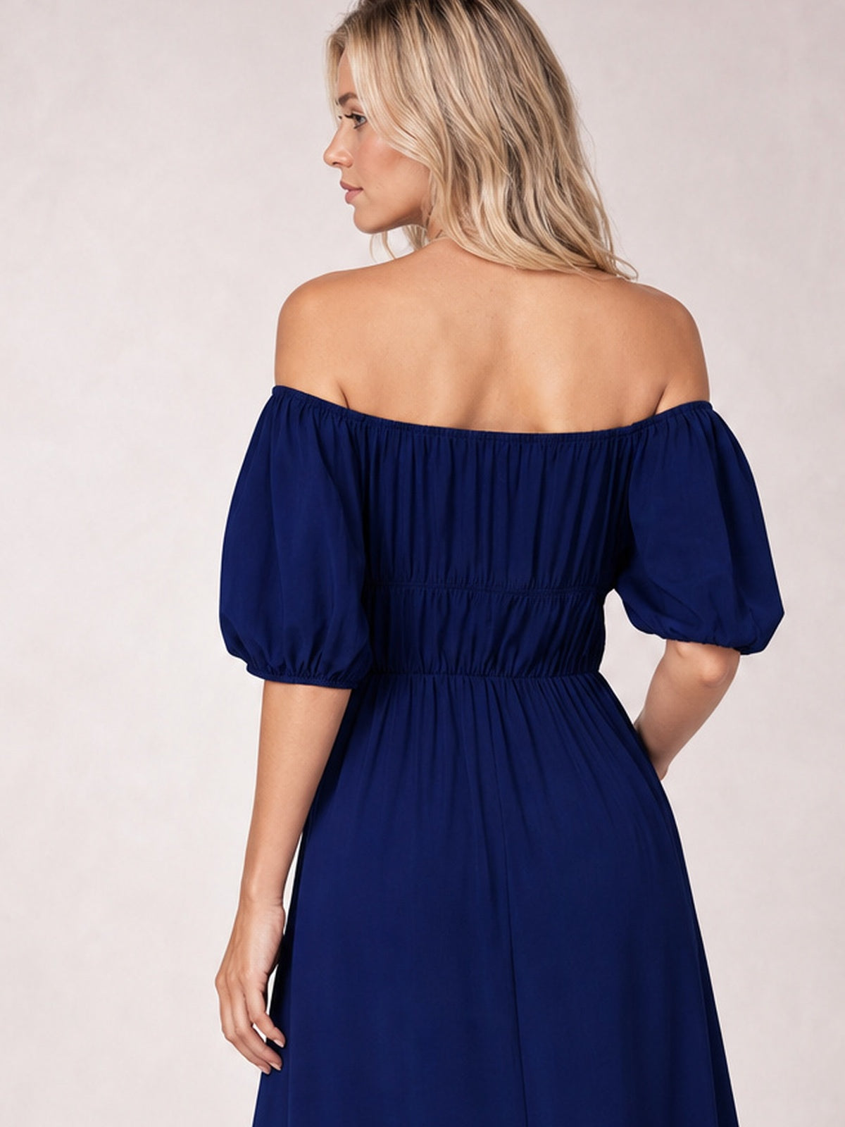 Model poses in a navy off-shoulder midi dress with voluminous half-length balloon sleeves, a gathered waist, and flowing A-line silhouette.