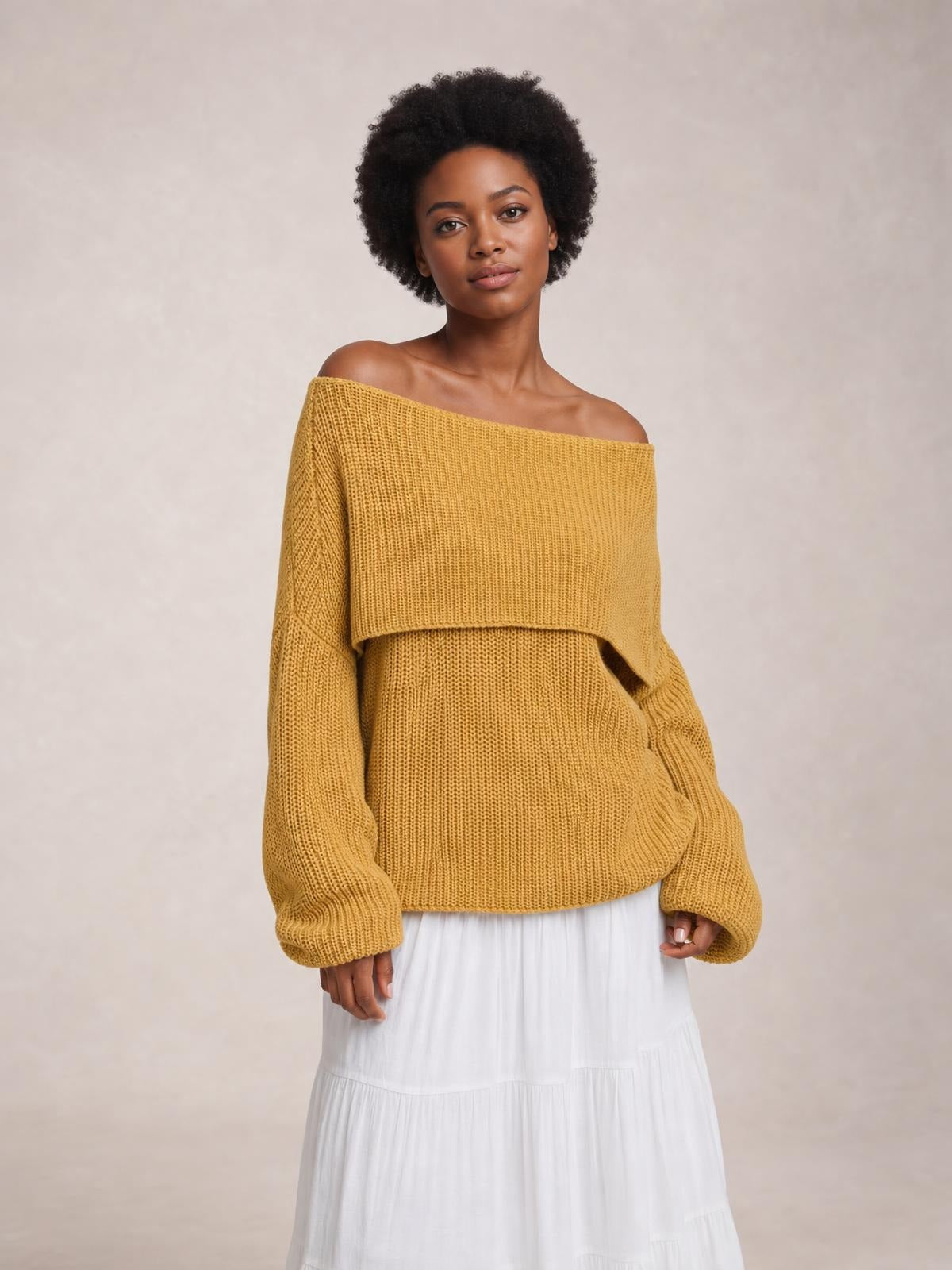 Model wears a mustard yellow oversized ribbed off-shoulder long sleeve sweater with a relaxed silhouette and dropped neckline.