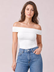 Model wearing a white off-shoulder short sleeve blouse with a fitted silhouette and wide folded neckline, paired with blue jeans.