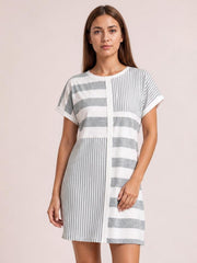 Model wearing a gray and white striped round-neck short-sleeve mini tee dress with a relaxed straight silhouette and contrasting horizontal and vertical stripes.