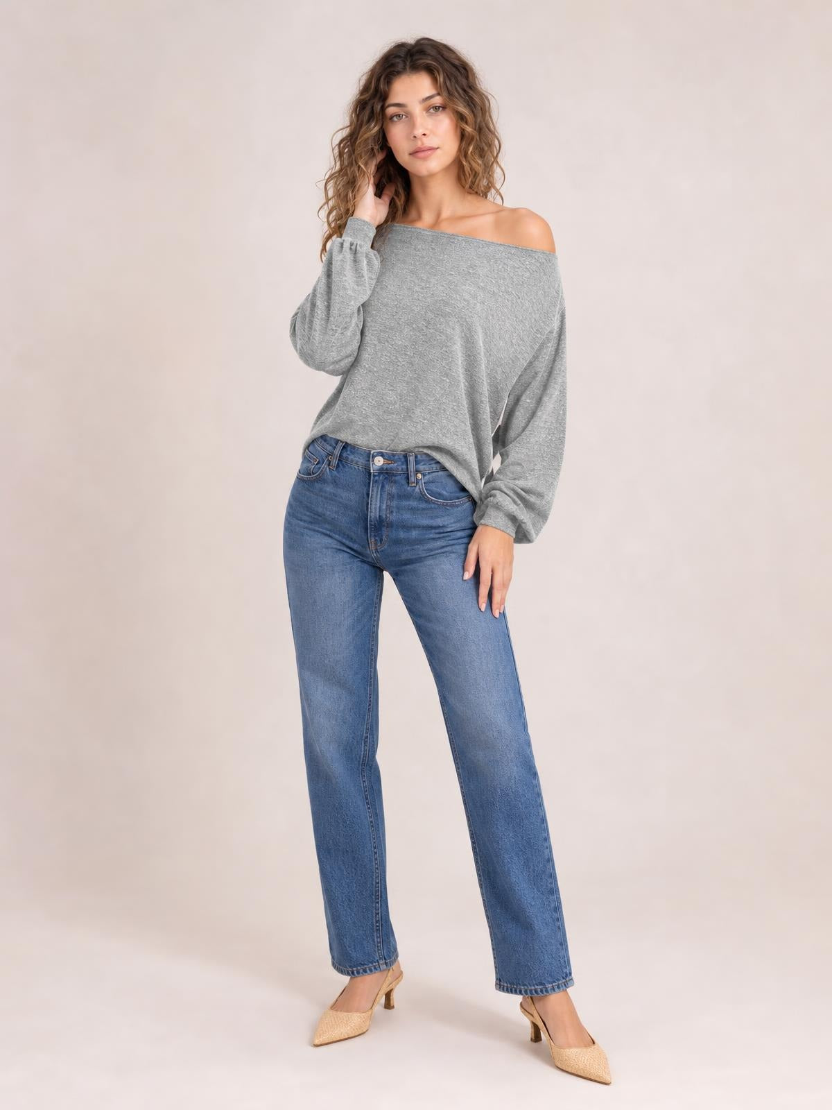 Model poses in a gray one-shoulder long-sleeve T-shirt with an asymmetric neckline, relaxed draped silhouette, and slightly gathered cuffs.
