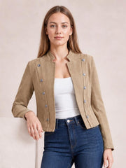 Model wearing a tan open-front cropped jacket with long sleeves, stand collar, structured seams, and multiple decorative buttons over a white top.