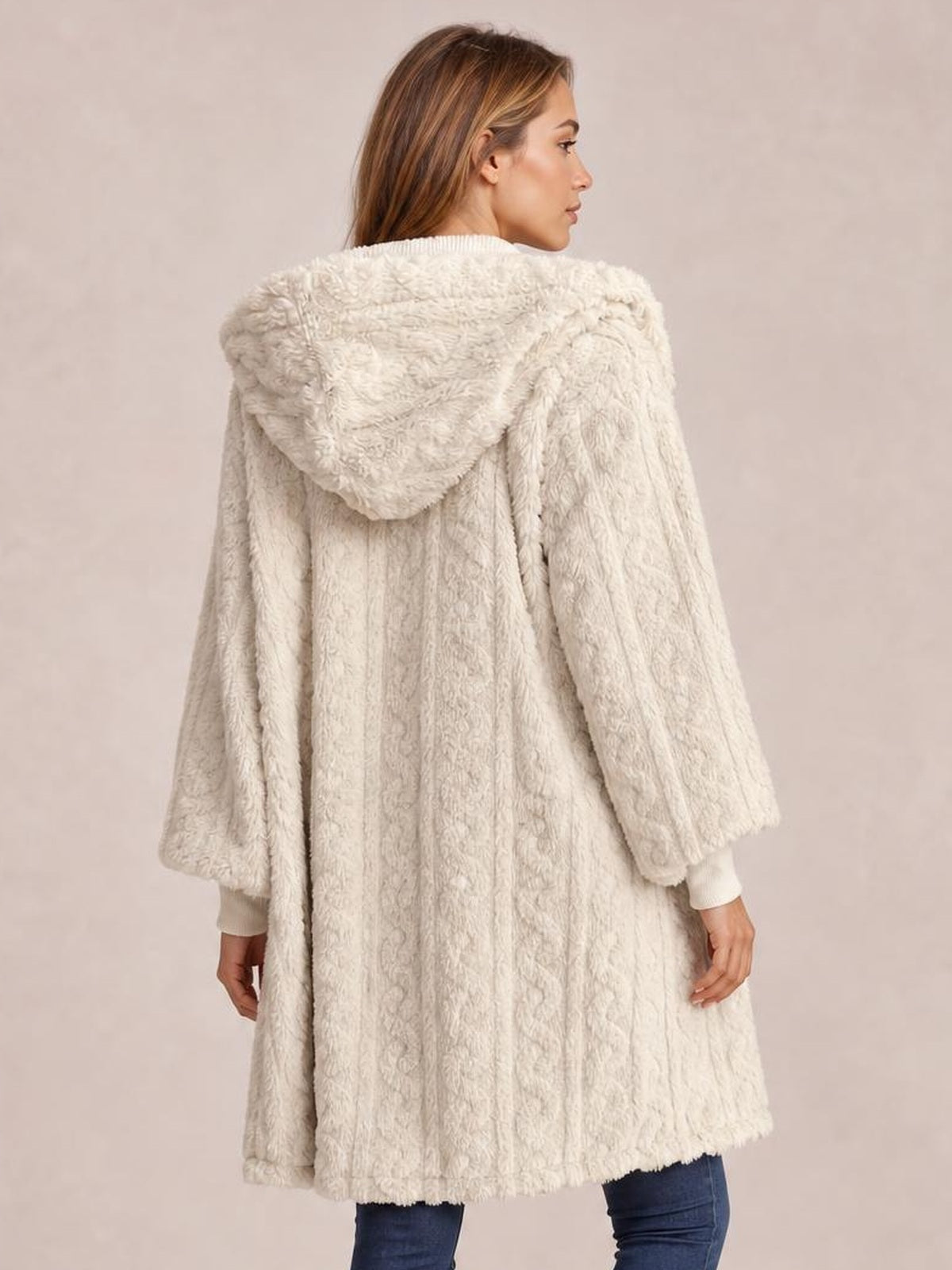Model turned away displays a cream fuzzy hooded jacket with long sleeves, open front, textured construction, and a relaxed longline silhouette.