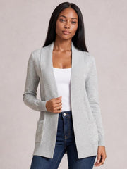 Model wearing a light gray open front long sleeve sweater cardigan with ribbed edges, patch pockets, and a relaxed hip-length silhouette over a white top.