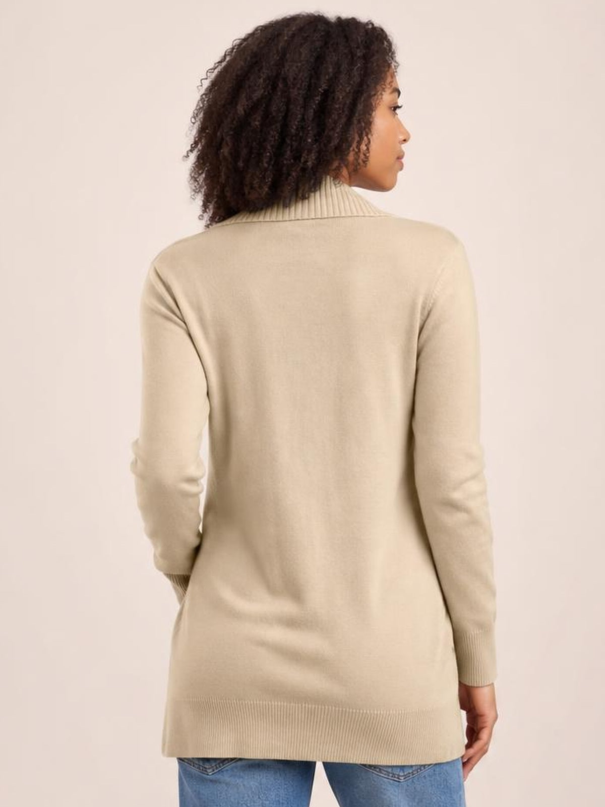 Model shown from behind in a beige long-sleeve sweater cardigan with a relaxed, slightly elongated silhouette and ribbed collar, cuffs, and hem.