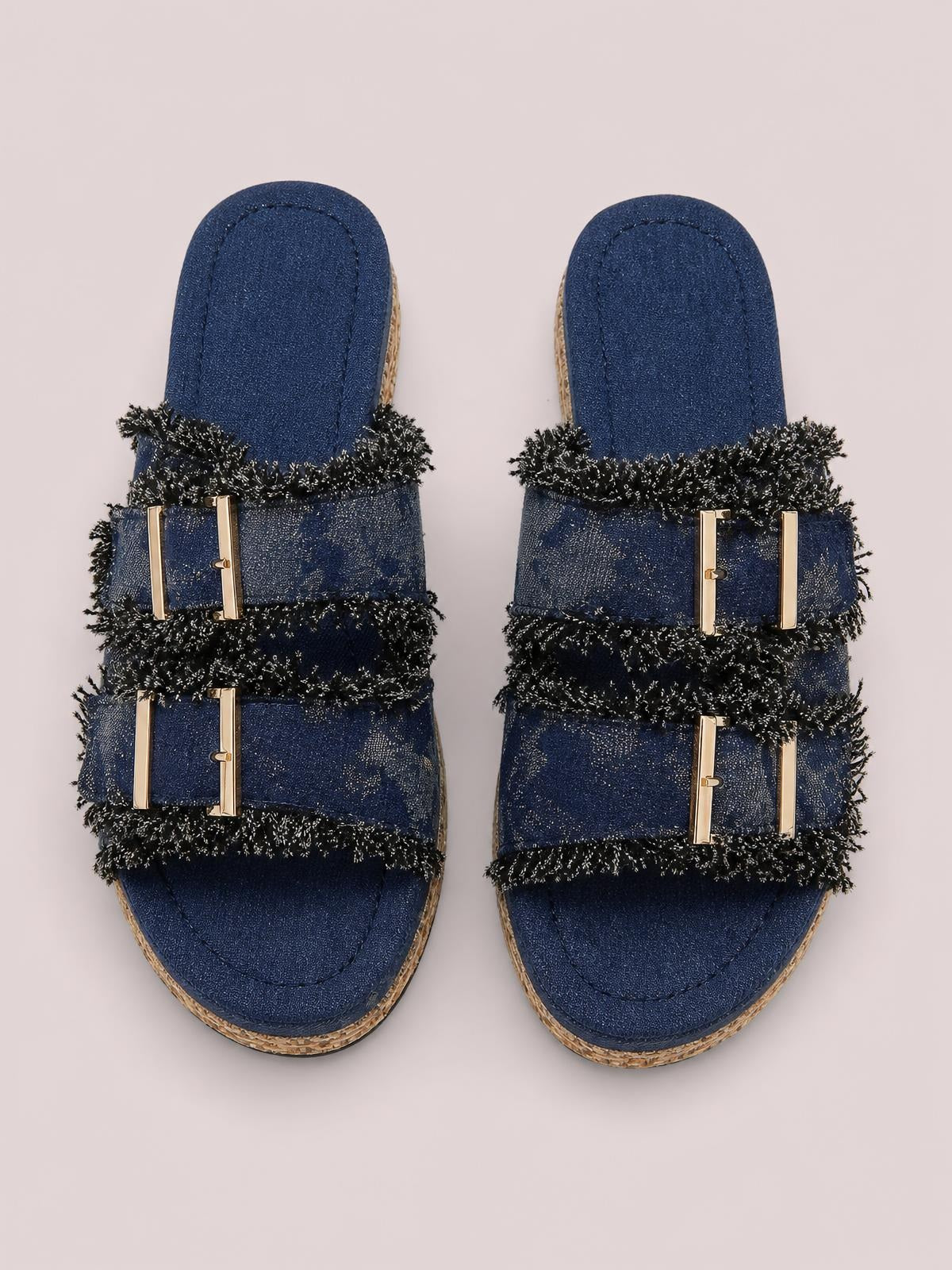 Navy open-toe double buckle platform sandals feature two textured straps with black fringe trim, gold-tone buckles, and flat woven-edged soles.