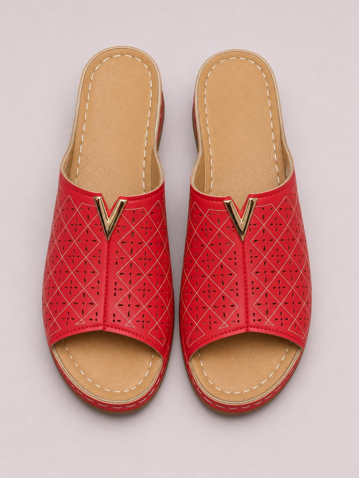 Red open-toe flat sandals in PU leather feature geometric perforated uppers, gold V accents, tan stitched insoles, and durable rubber soles.