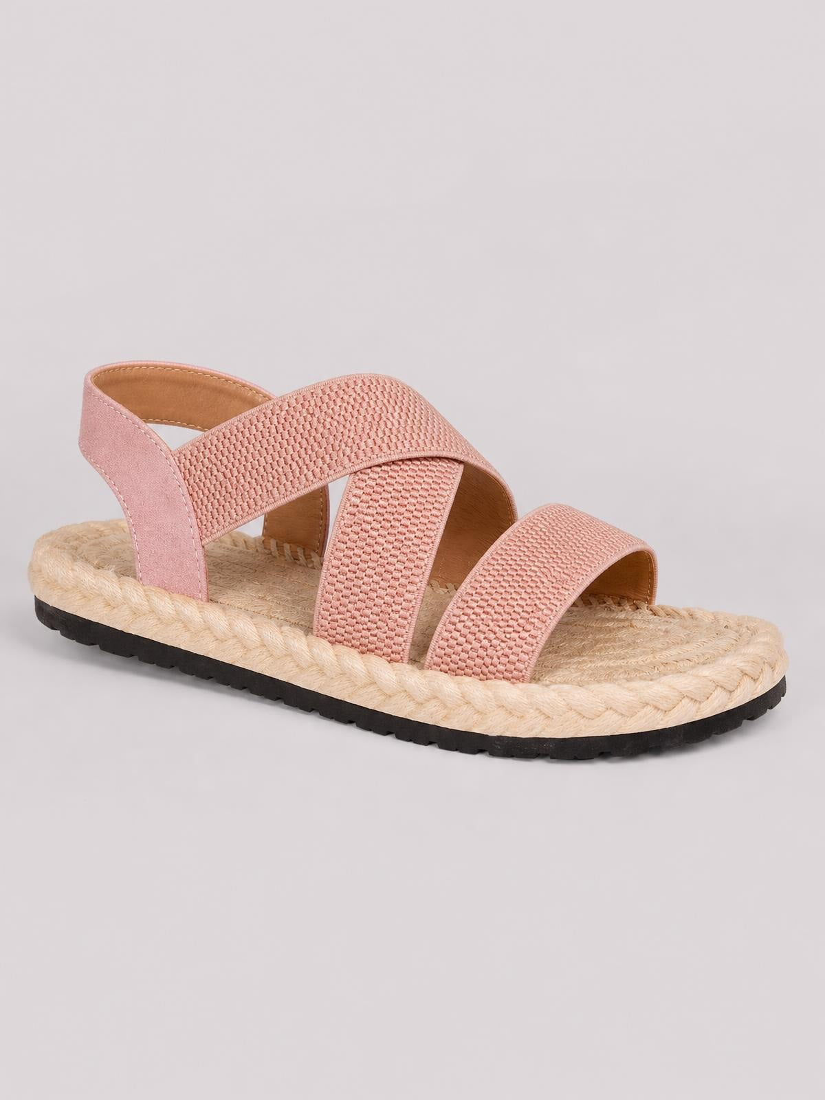 Pink open toe flat sandals with woven crossover straps, a supportive heel strap, textured footbed, braided trim, and black rubber soles.