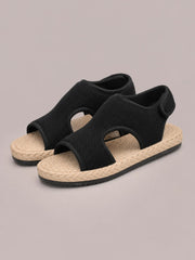 Black open toe mesh flat sandals feature breathable upper panels, rounded side cutouts, woven-look footbeds, and durable black rubber soles.