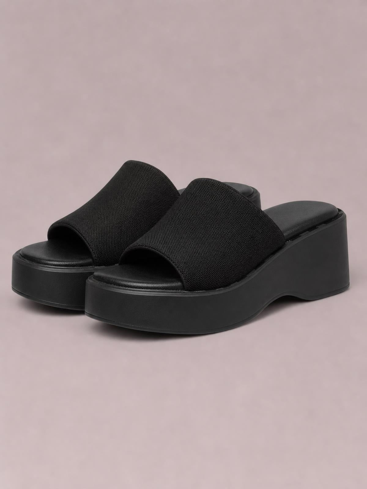 Black open-toe platform cloth sandals with wide textured straps, cushioned footbeds, and chunky rubber wedge soles.