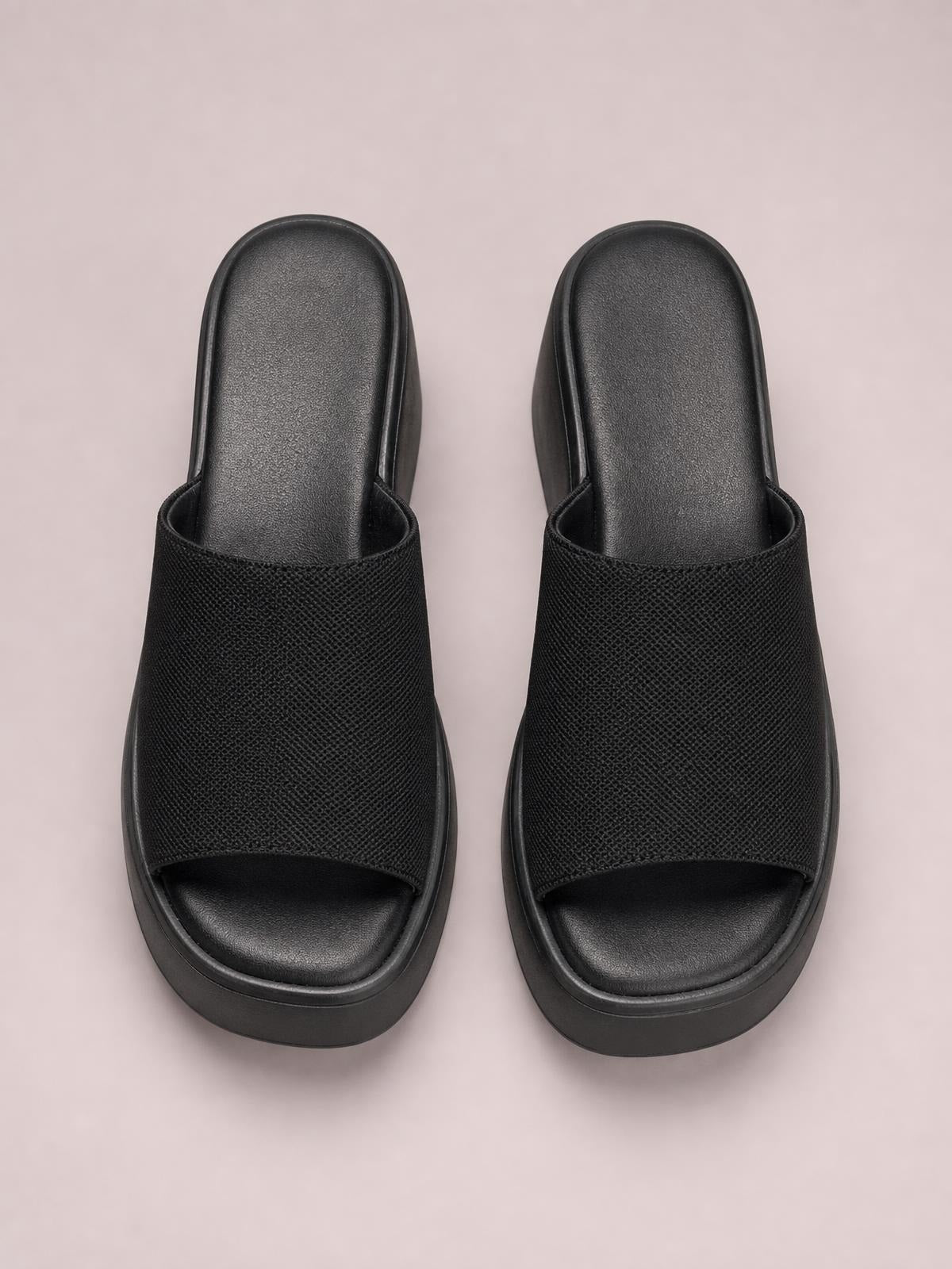 Black open-toe platform cloth sandals with wide textured straps, cushioned footbeds, and thick flat rubber soles.