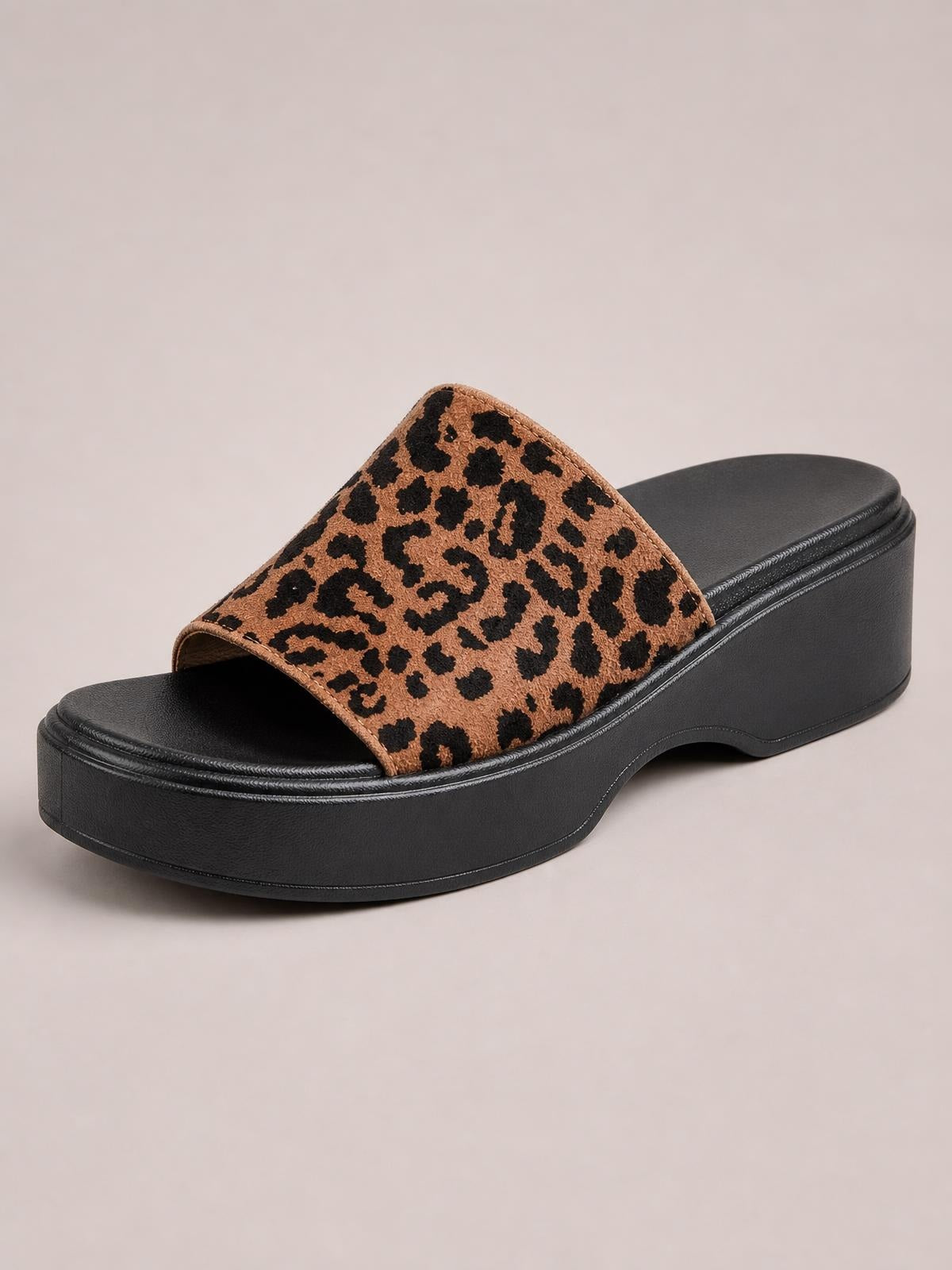 Leopard-print cloth open-toe platform sandal with a wide slip-on upper, black footbed, and thick molded rubber sole with stitched edging.