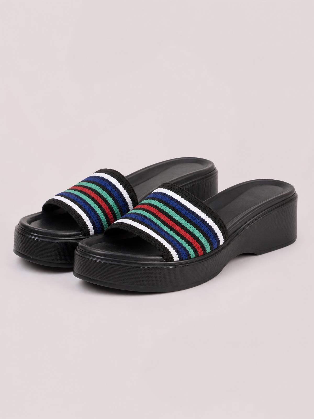 Black open-toe platform cloth sandals with colorful horizontal striped straps, rounded toes, and chunky textured rubber wedge soles.