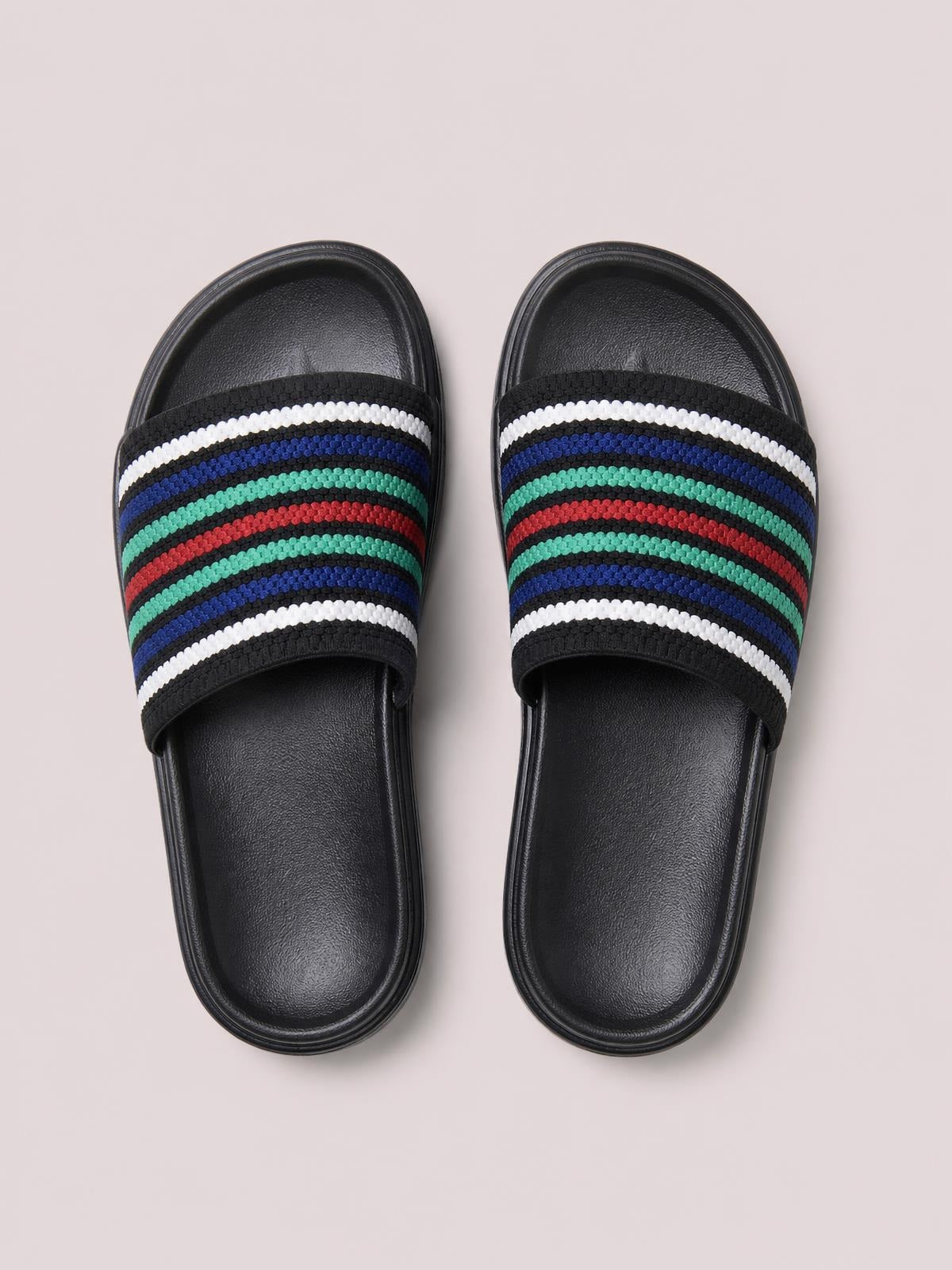 Black open-toe platform cloth sandals feature wide striped straps in white, blue, mint, and red over cushioned footbeds with flat rubber soles.