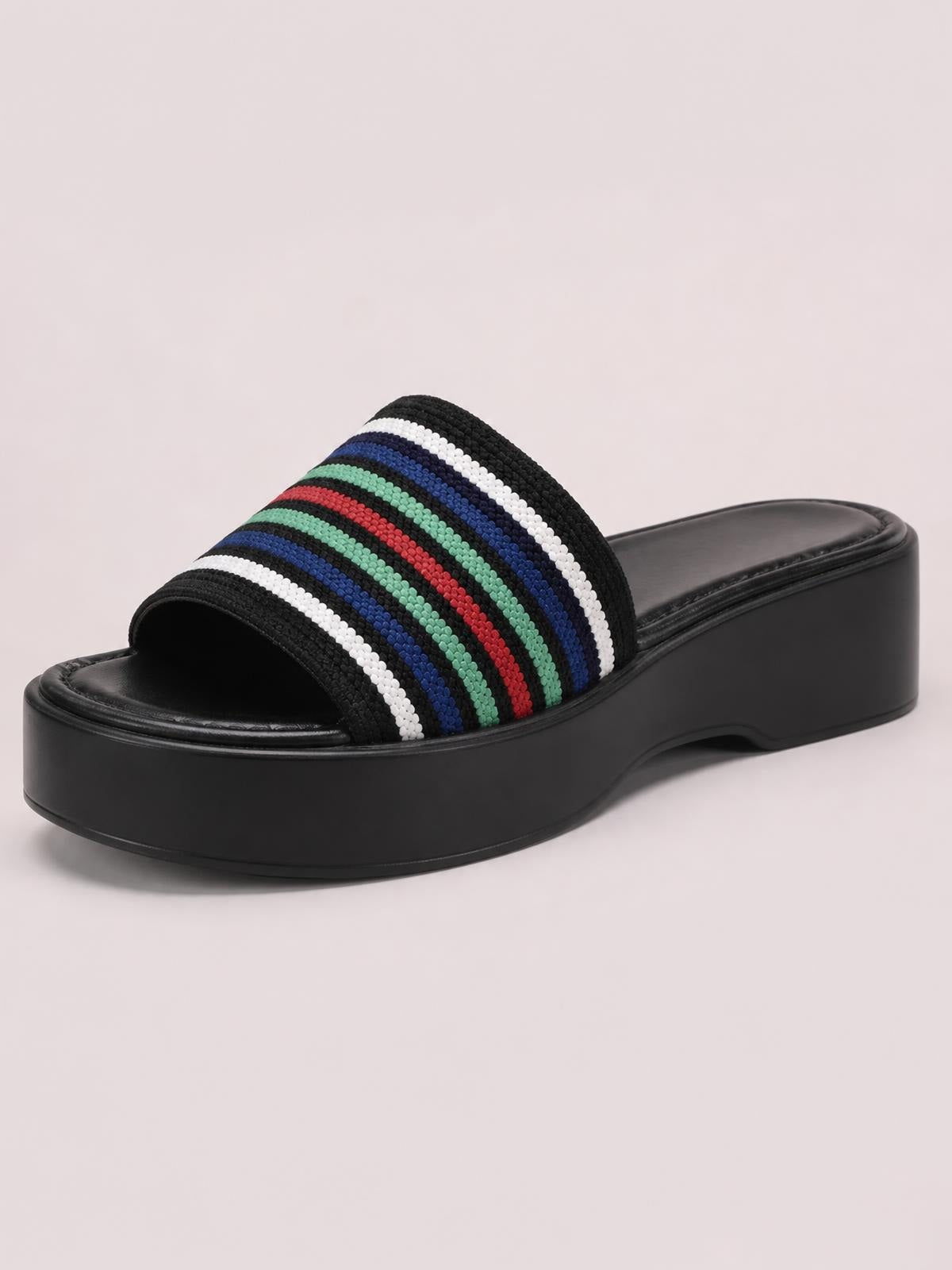 Open-toe cloth sandal with a black platform sole and wide woven strap featuring black, white, blue, green, and red horizontal stripes.