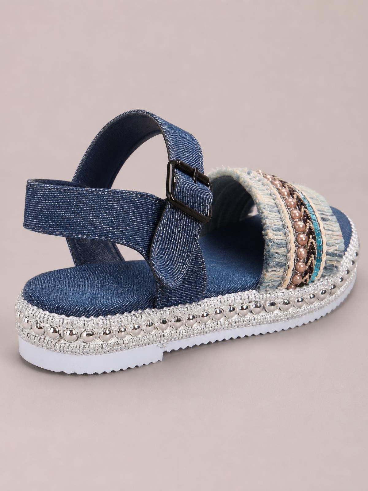 Blue denim open-toe platform sandals feature wide adjustable buckle straps, silver bead-trimmed soles, and chunky white rubber outsoles.