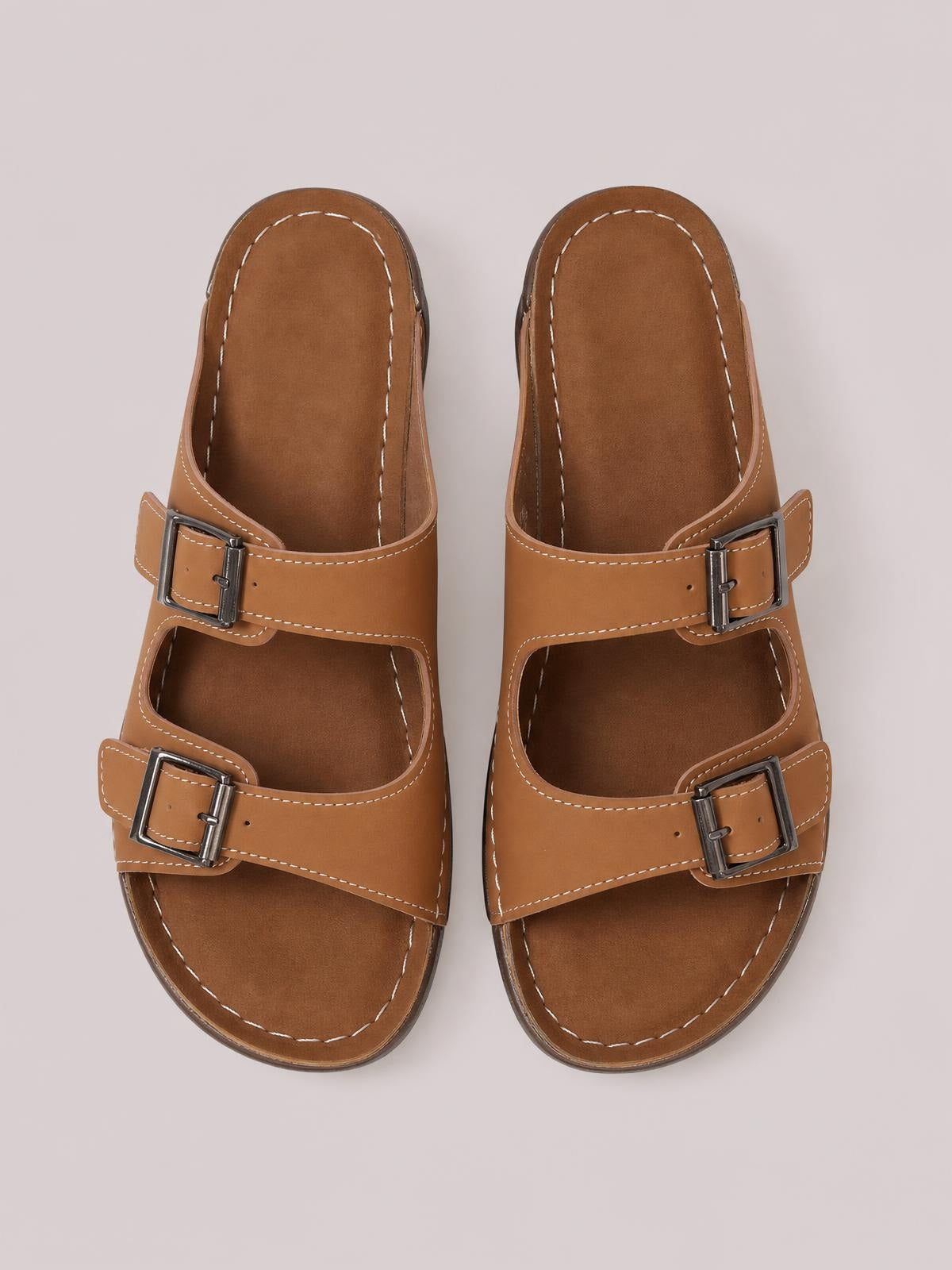 Brown open toe platform sandals feature double adjustable buckle straps, contrast stitching, cushioned footbeds, and sturdy flat rubber soles.