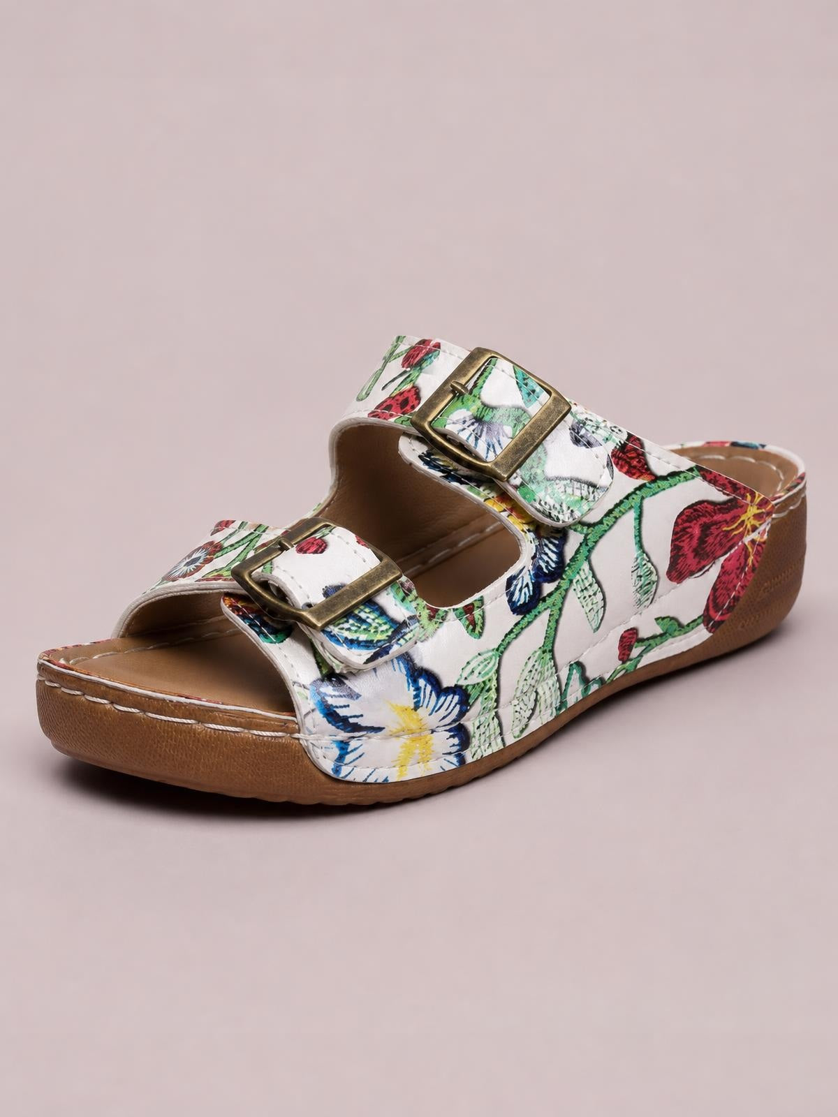 White floral open toe platform sandals feature two adjustable buckle straps, a cushioned footbed, and a sturdy flat rubber sole.