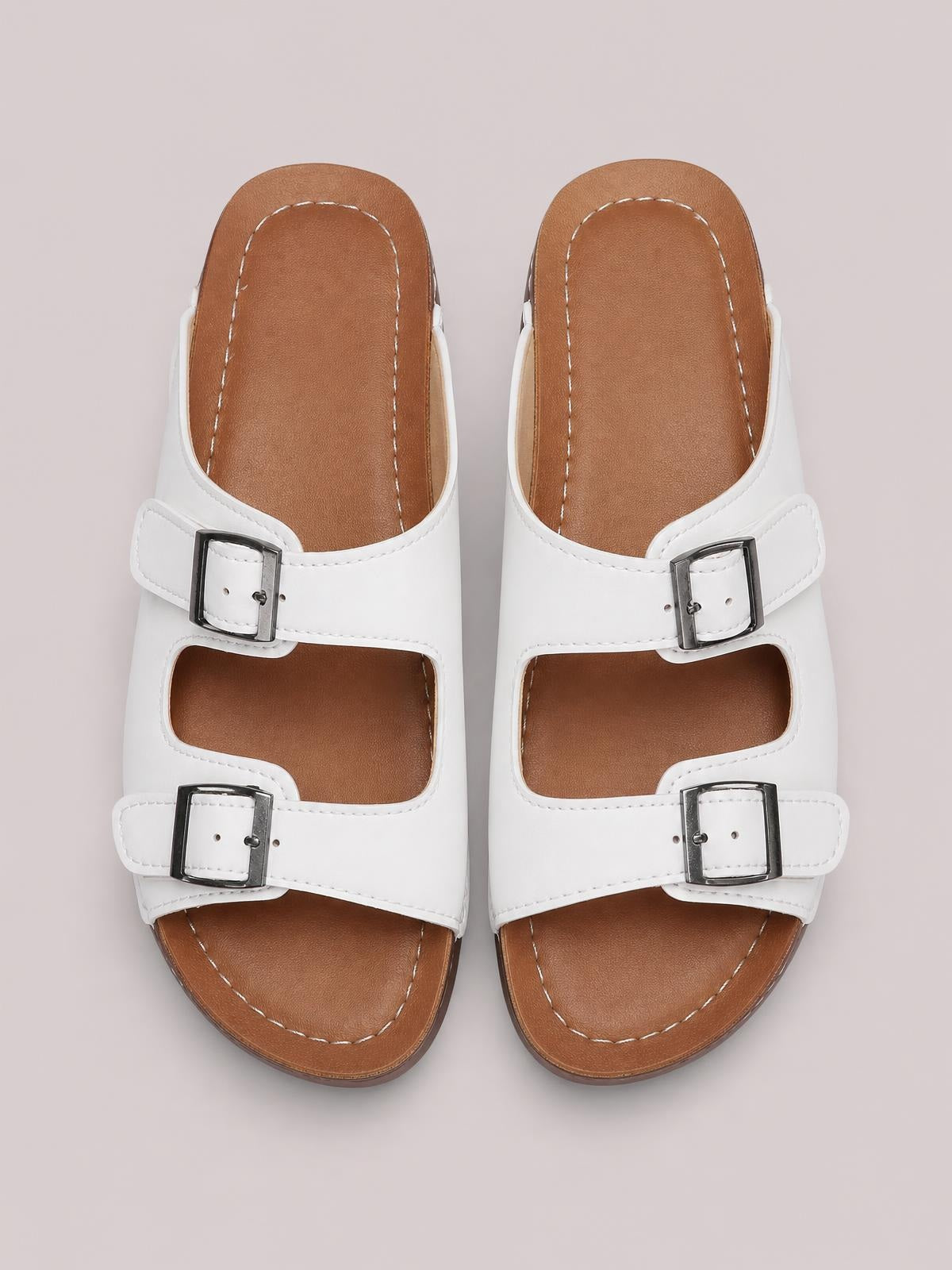 White open toe platform sandals with two adjustable buckle straps, tan cushioned footbeds, stitched construction, and flat rubber soles.