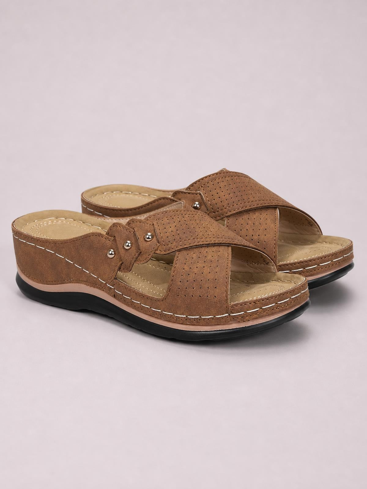 Brown open-toe platform sandals in PU leather feature perforated wide straps, decorative studs, contrast stitching, cushioned footbeds, and black rubber soles.