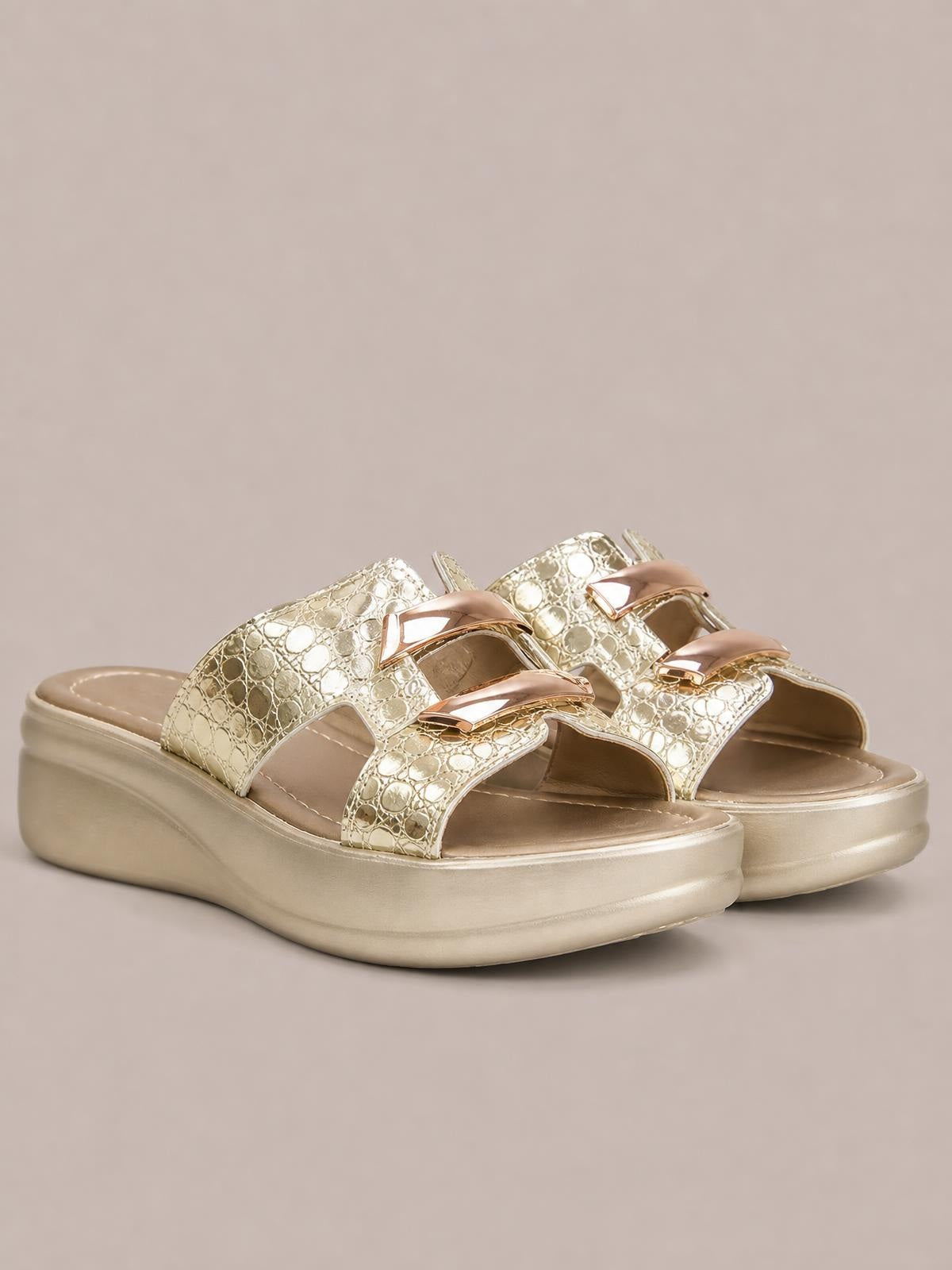 Gold open-toe platform wedge sandals feature wide patterned straps, metallic rose-gold accents, cushioned footbeds, and mid-height wedge soles.